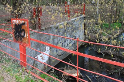 Pool in wood  fenced with a metal red fence.