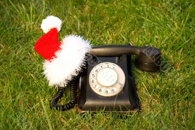 Old fashioned black telephone with Santa`s hat