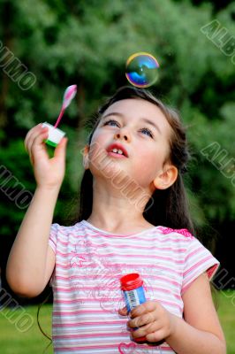 The little girl starts up soap bubbles