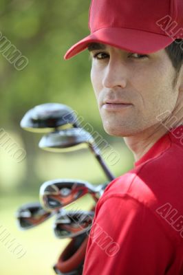 Golfer holding golf clubs.