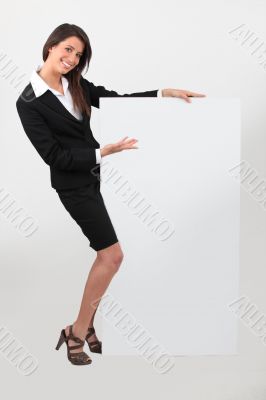 Portrait of woman in skirt suit with blank board
