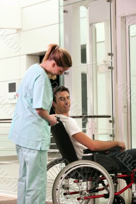 Nurse and patient in wheelchair in front of a lift