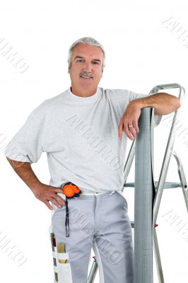 Middle-aged man with ladder and roll of wallpaper