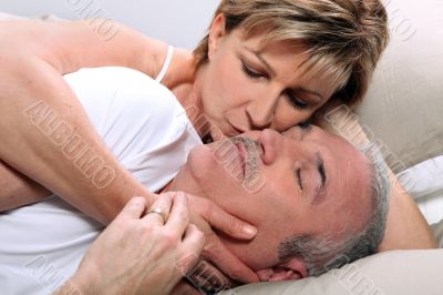 Woman kissing her sleeping husband