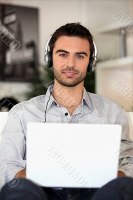 young music lover with earphones and laptop
