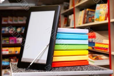 Stack of colorful books with e-book reader