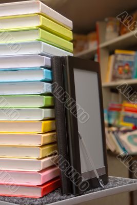 Stack of colorful books with e-book reader