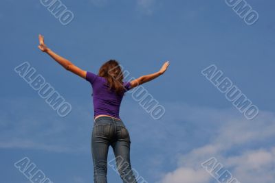 Young woman staying with raised hands