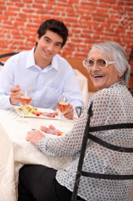 Woman enjoying a meal out with her grandson