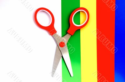 Colorful paper with child`s scissors