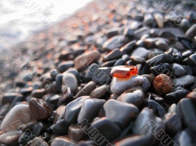 Orange glass laying on the sea shore