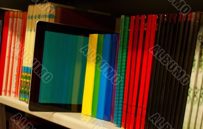 Row of colorful books and electronic book reader