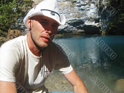 Man in white hat on the lake shore