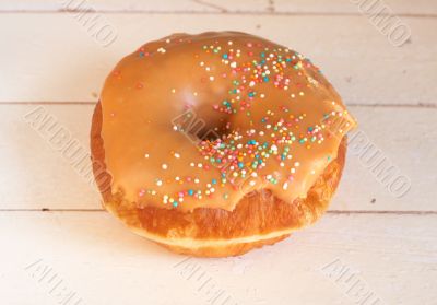 Donut covered in caramel icing and sprinkles