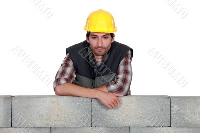Young mason leaning on a wall