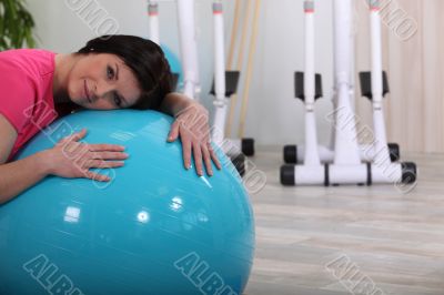 Sporty woman leaning on a fitness balloon