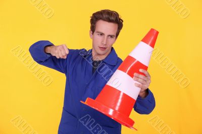 man hitting a traffic cone