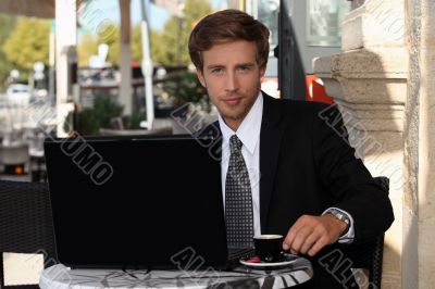 Young businessman having coffee outdoors Young businessman having coffee outdoors
