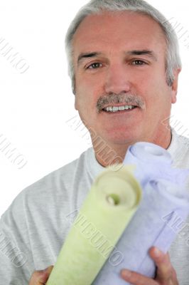 Decorator holding rolls of wallpaper