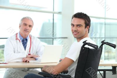 Young man in a wheelchair talking to a doctor