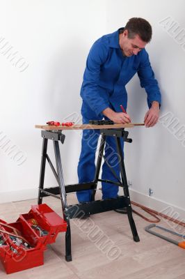 a craftsman tracing on a workbench