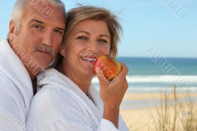Mature couple in bathrobes on the beach Mature couple in bathrobes on the beach