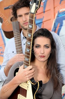 young woman and man playing in a music band young woman and man playing in a music band