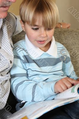 Grandfather reading a book with his grandson