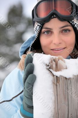 Woman standing behind a wooden post