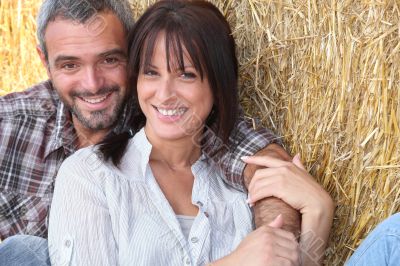 Farming couple sitting in the hay