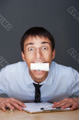 Closeup portrait of business man holding business card in his mouth