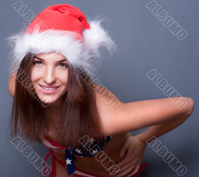 20-25 years old beautiful woman in christmas hat and swimsuit