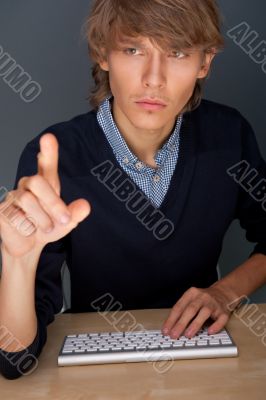 Young business man pressing a touchscreen button while working