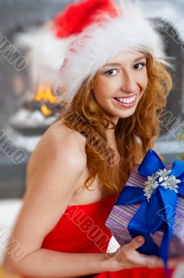 Christmas woman near a Christmas tree holding big gift box.