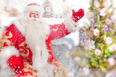 Santa sitting at the Christmas tree, near fireplace. 