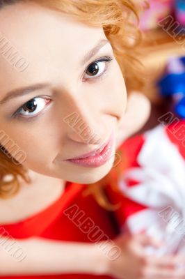 Christmas woman near a Christmas tree holding big gift box.