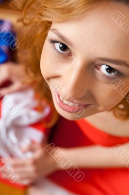 Christmas woman near a Christmas tree holding big gift box.