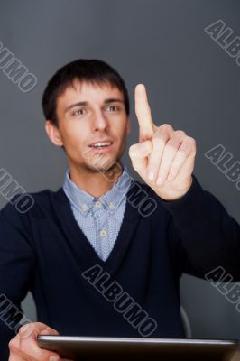 Young business man pressing a touchscreen button while working.