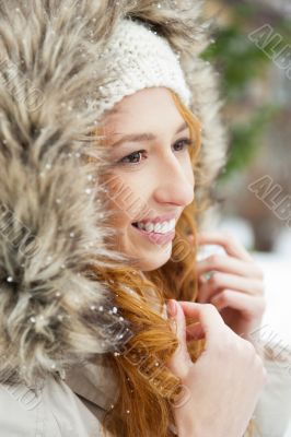 Portrait of pretty girl at winter background wearing warm clothes.