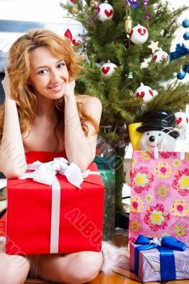 Christmas woman near a Christmas tree holding big gift box while