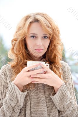 Portrait of young pretty red hair woman with cup of hot coffee o