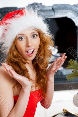 Christmas woman near a Christmas tree very excited while sitting