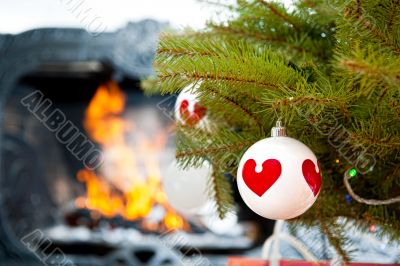 Christmas baubles against burning flame in fireplace on christma