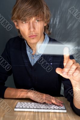 Young business man pressing a touchscreen button while working a