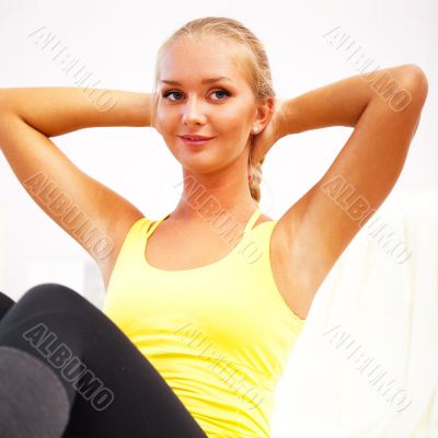 Portrait of beautiful young woman doing exercise at her home