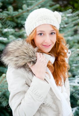 Portrait of young pretty woman in winter park 