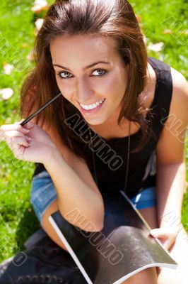 A shot of an caucasian student studying on campus lawn