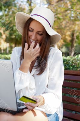 Young elegant woman wearing straw hat and white dress holding cr