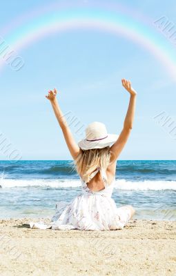 Portrait of young woman on the beach near the sea sitting with h