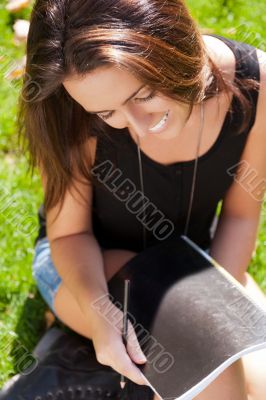 A shot of an caucasian student studying on campus lawn